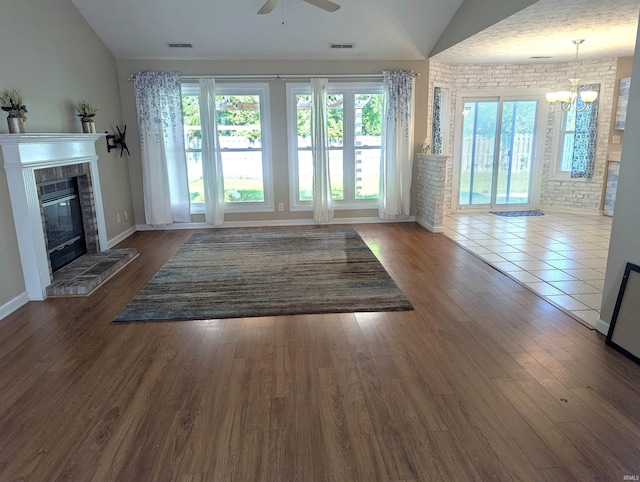 2220 Bobolink Dr, West Lafayette, IN 47906 - unfurnished living room with ceiling fan, lofted ceiling, a glass covered fireplace, a chandelier, and wood finished floors