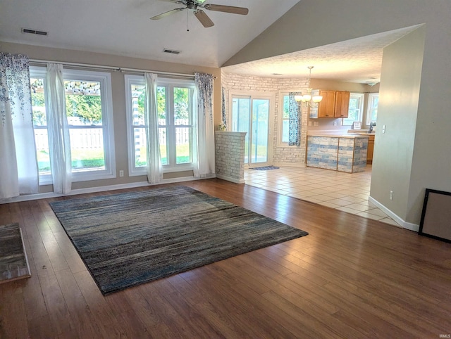 2220 Bobolink Dr, West Lafayette, IN 47906 - unfurnished living room featuring a ceiling fan, a chandelier, wood-type flooring, and high vaulted ceiling
