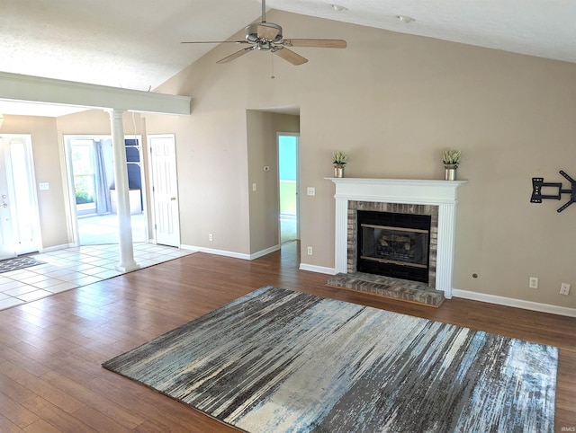 2220 Bobolink Dr, West Lafayette, IN 47906 - unfurnished living room featuring decorative columns, wood finished floors, ceiling fan, high vaulted ceiling, and a glass covered fireplace
