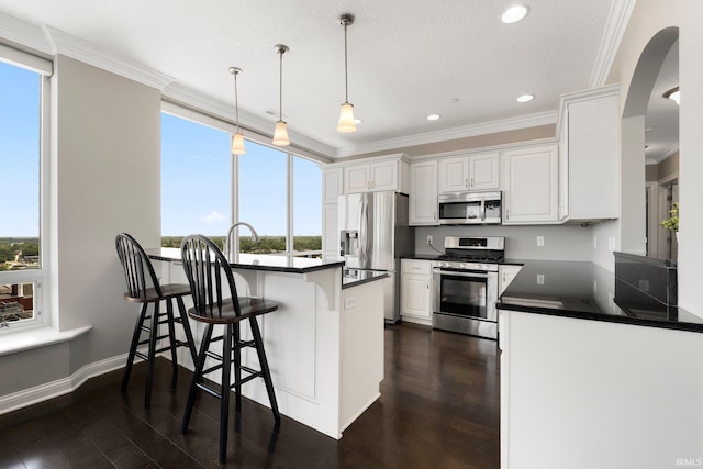 203 E Berry St Unit 1507, Fort Wayne, IN 46802 - kitchen with appliances with stainless steel finishes, dark countertops, a peninsula, crown molding, and white cabinets
