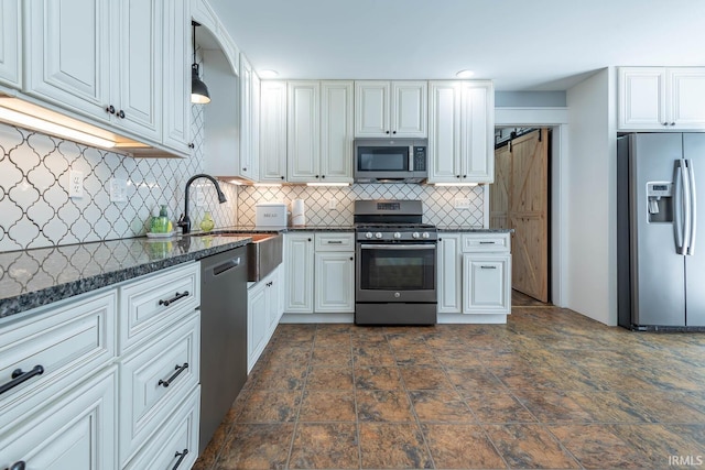 3523 S Tulip Ave, Bloomington, IN 47403 - kitchen with stainless steel appliances, tasteful backsplash, white cabinets, dark stone counters, and dark stone finish flooring