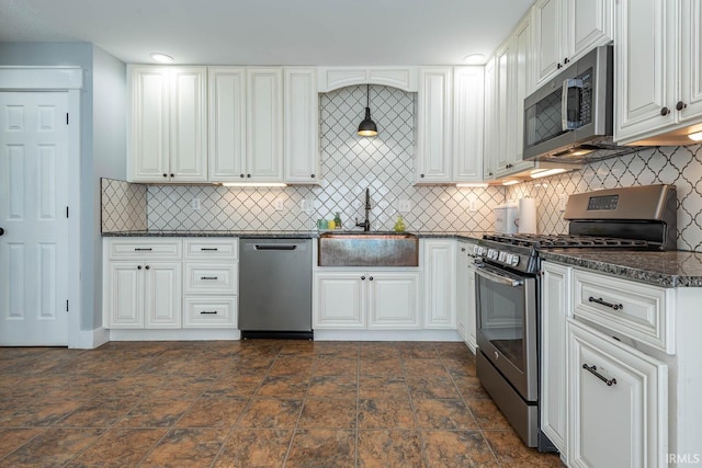 3523 S Tulip Ave, Bloomington, IN 47403 - kitchen with stainless steel appliances, decorative backsplash, white cabinets, dark stone finish flooring, and dark stone countertops