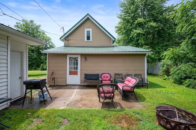 315 Mill St, Geneva, IN 46740 - rear view of property with a lawn, a patio area, a metal roof, and an outdoor living space with a fire pit