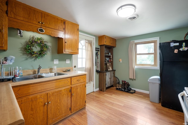 315 Mill St, Geneva, IN 46740 - kitchen featuring freestanding refrigerator, light wood-style flooring, healthy amount of natural light, and light countertops