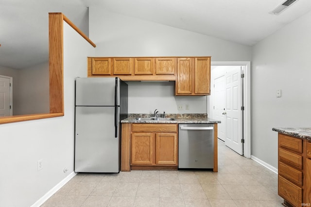 806 Deer Ridge Xing, Auburn, IN 46706 - kitchen with stainless steel appliances, lofted ceiling, brown cabinets, light tile patterned floors, and dark countertops