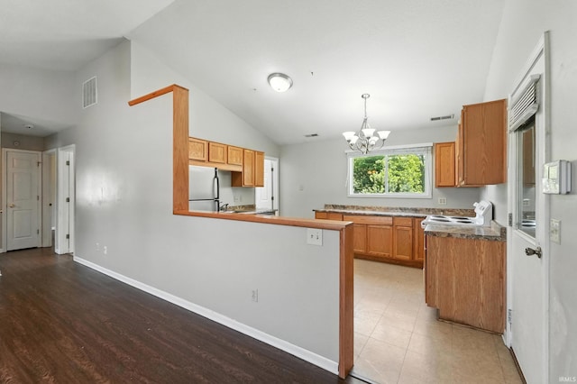 806 Deer Ridge Xing, Auburn, IN 46706 - kitchen with white appliances, a chandelier, brown cabinetry, a peninsula, and pendant lighting