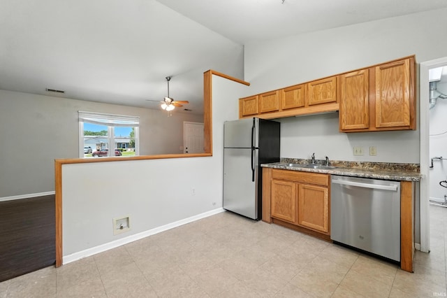 806 Deer Ridge Xing, Auburn, IN 46706 - kitchen featuring appliances with stainless steel finishes, dark countertops, vaulted ceiling, a ceiling fan, and brown cabinetry