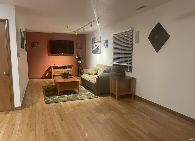 1074 Chapman Lake Dr, Warsaw, IN 46582 - living room featuring rail lighting and light wood-style floors