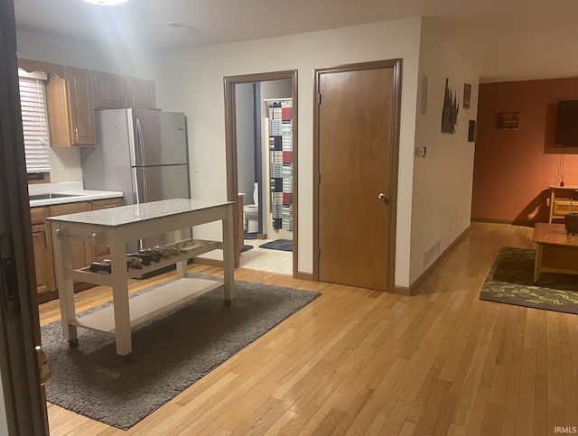 1074 Chapman Lake Dr, Warsaw, IN 46582 - kitchen with light countertops, light wood-type flooring, and freestanding refrigerator