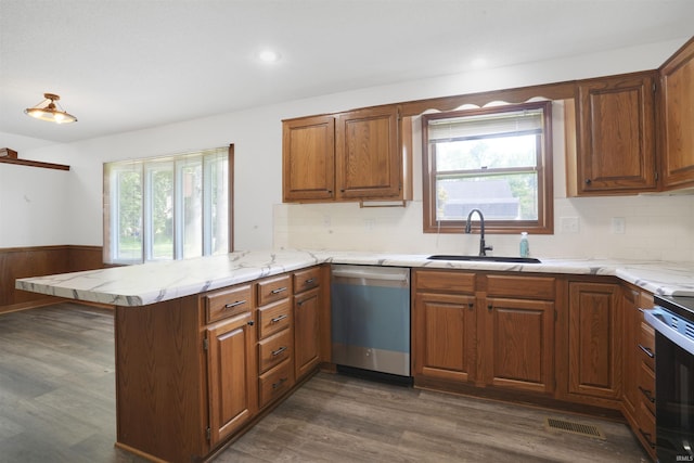 741 Christopher Dr, Evansville, IN 47711 - kitchen with stainless steel dishwasher, a peninsula, brown cabinets, dark wood-style flooring, and decorative backsplash