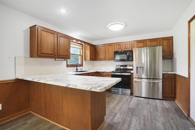 741 Christopher Dr, Evansville, IN 47711 - kitchen with stainless steel appliances, a peninsula, brown cabinetry, dark wood-type flooring, and tasteful backsplash
