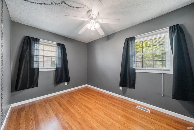6701 Bittersweet Dr, Fort Wayne, IN 46825 - empty room featuring plenty of natural light, wood finished floors, a textured ceiling, and a ceiling fan
