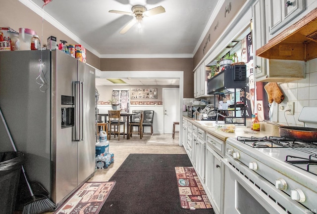 517 S Kaley St, South Bend, IN 46619 - kitchen featuring high quality fridge, white gas stove, ornamental molding, a ceiling fan, and light countertops