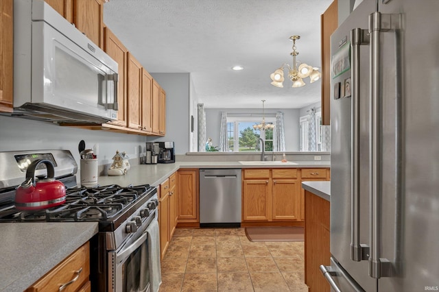 5506 Getty Ct, Granger, IN 46530 - kitchen with stainless steel appliances, a chandelier, pendant lighting, recessed lighting, and light countertops