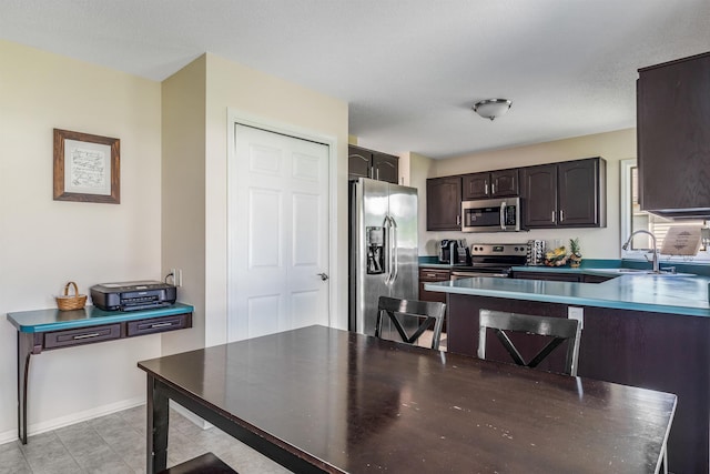10414 Unita Dr, Fort Wayne, IN 46804 - kitchen featuring appliances with stainless steel finishes, dark brown cabinets, and a peninsula