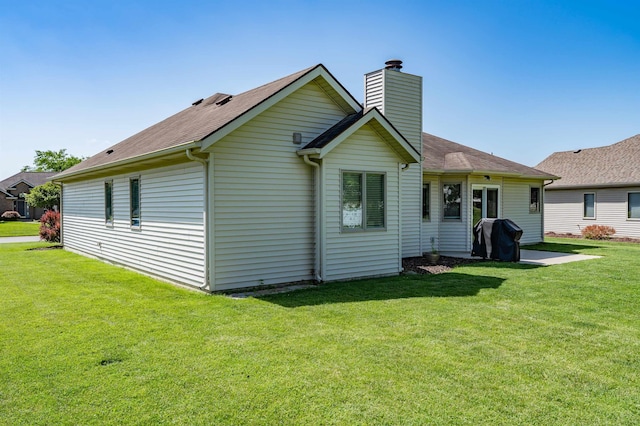10414 Unita Dr, Fort Wayne, IN 46804 - back of house with a chimney, a lawn, and a shingled roof
