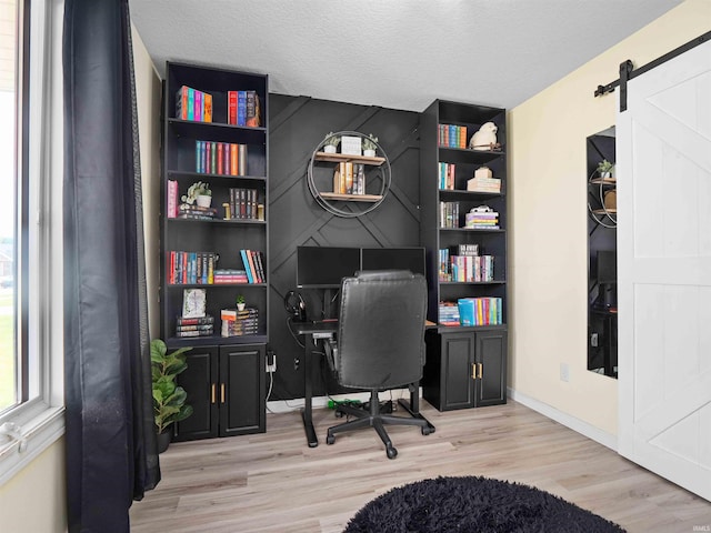 2479 Trillium Cv, Huntertown, IN 46748 - office area with wood finished floors, a barn door, and a textured ceiling