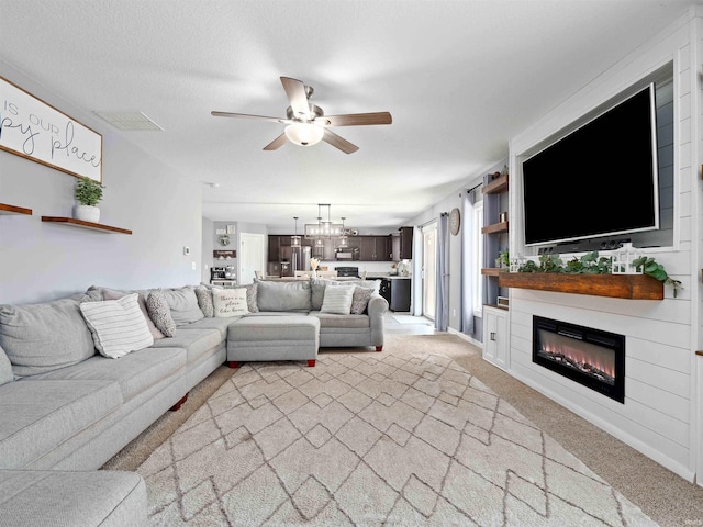 2479 Trillium Cv, Huntertown, IN 46748 - living room with light carpet, a ceiling fan, and a glass covered fireplace