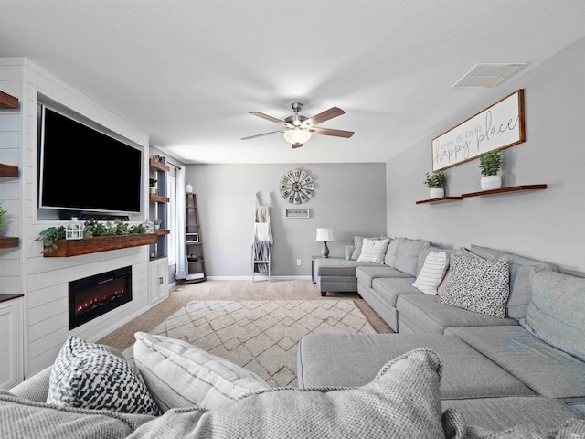 2479 Trillium Cv, Huntertown, IN 46748 - living area with carpet floors, a ceiling fan, and a glass covered fireplace