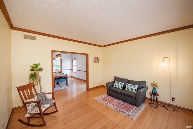 3827 Sunnycroft Pl, West Lafayette, IN 47906 - living area featuring light wood-style floors, a chandelier, a textured ceiling, and crown molding