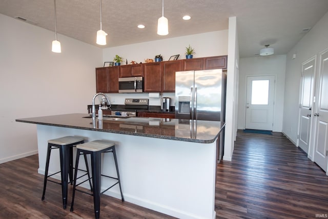 6471 Wallingford St, Lafayette, IN 47905 - kitchen with appliances with stainless steel finishes, dark wood finished floors, a breakfast bar area, a textured ceiling, and hanging light fixtures