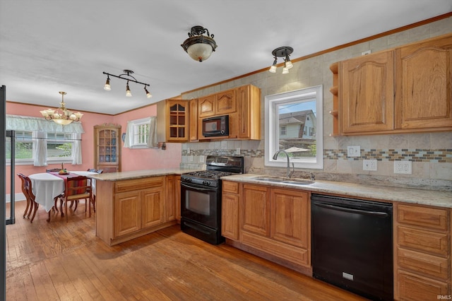 412 Tonti Ave, South Bend, IN 46617 - kitchen featuring black appliances, a peninsula, a chandelier, light wood-type flooring, and crown molding