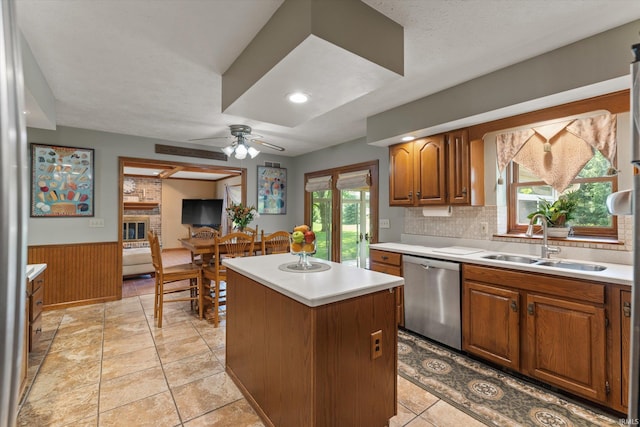 51769 S Saddle Ridge Ln, Granger, IN 46530 - kitchen featuring dishwasher, light countertops, a center island, ceiling fan, and a wainscoted wall