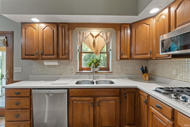 51769 S Saddle Ridge Ln, Granger, IN 46530 - kitchen with appliances with stainless steel finishes, light countertops, brown cabinetry, and decorative backsplash