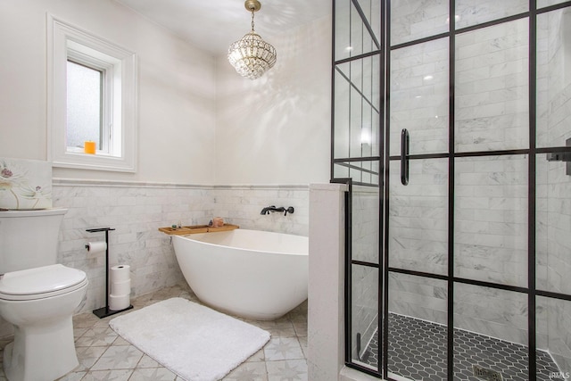 4 Edgewater Pl, Elkhart, IN 46516 - full bathroom with a soaking tub, a stall shower, wainscoting, a chandelier, and tile walls