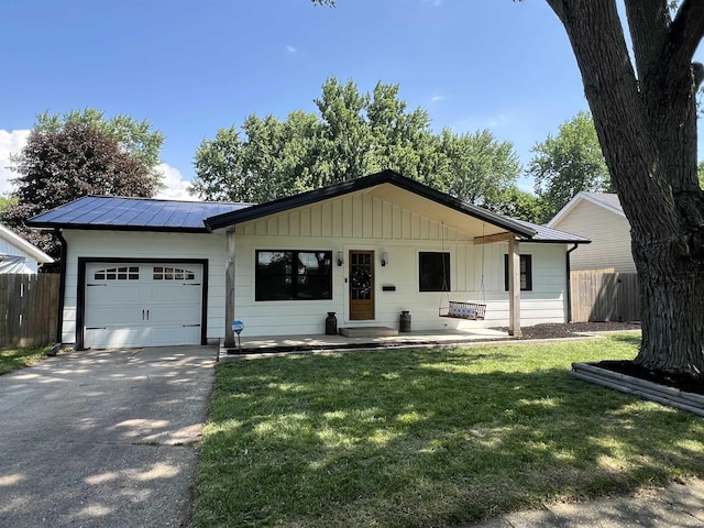 1503 W Ave, Goshen, IN 46526 - view of front facade featuring an attached garage, driveway, a metal roof, and a standing seam roof