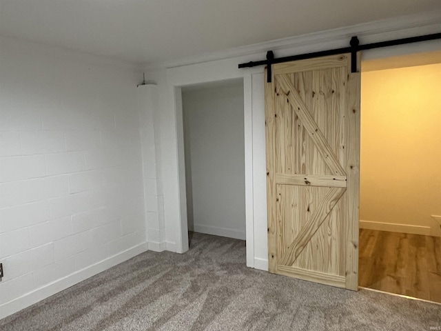 1503 W Ave, Goshen, IN 46526 - unfurnished bedroom with a barn door, carpet, and ornamental molding