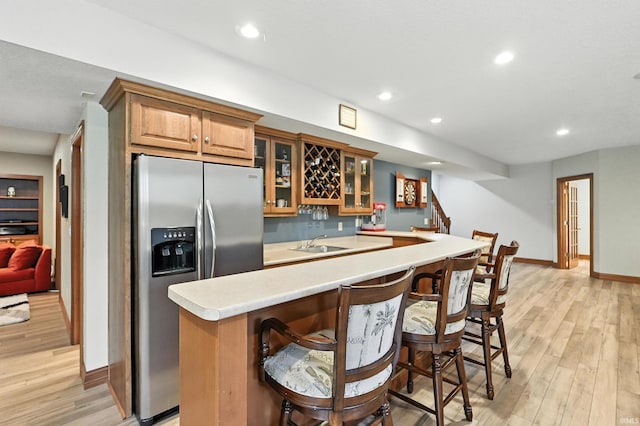 1208 Phaeton Way, Auburn, IN 46706 - kitchen with stainless steel refrigerator with ice dispenser, light wood-style flooring, light countertops, recessed lighting, and glass insert cabinets