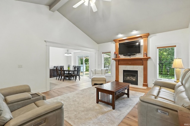 1208 Phaeton Way, Auburn, IN 46706 - living area with beam ceiling, a tiled fireplace, a ceiling fan, light wood finished floors, and high vaulted ceiling