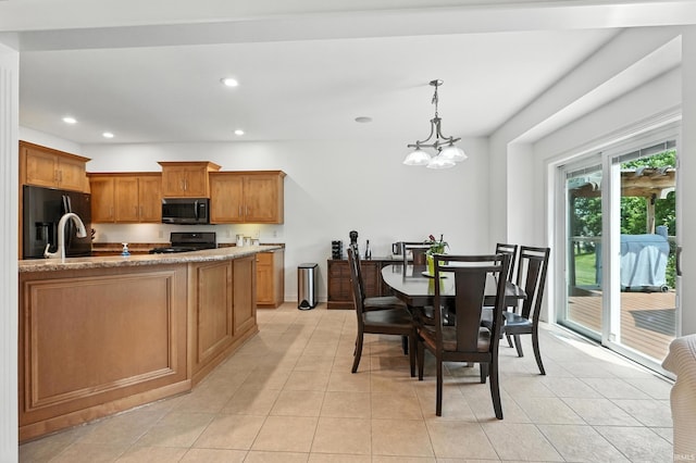 1208 Phaeton Way, Auburn, IN 46706 - kitchen with black fridge, range with gas cooktop, recessed lighting, brown cabinets, and pendant lighting