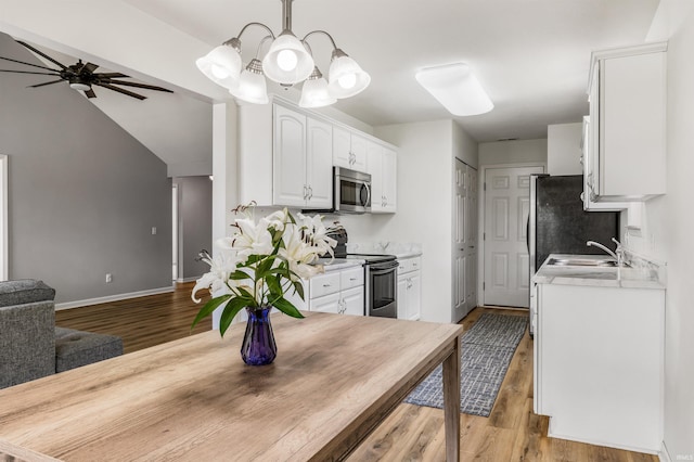 12909 Cocoplum Ct, Fort Wayne, IN 46814 - kitchen featuring appliances with stainless steel finishes, white cabinets, wood finished floors, light countertops, and a ceiling fan
