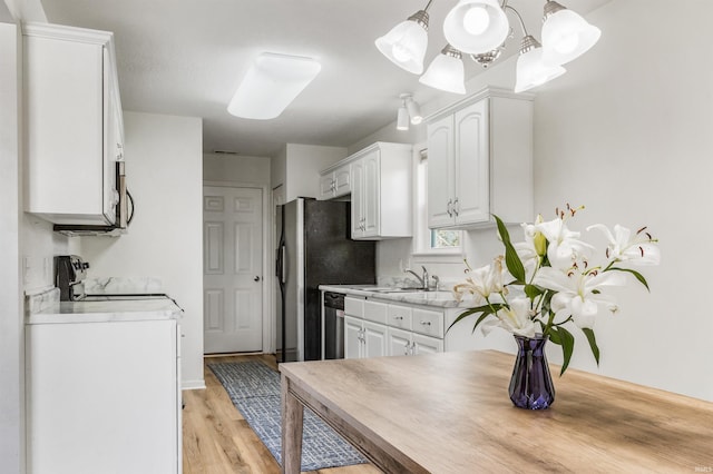 12909 Cocoplum Ct, Fort Wayne, IN 46814 - kitchen featuring stainless steel appliances, white cabinets, a chandelier, and light wood-style flooring