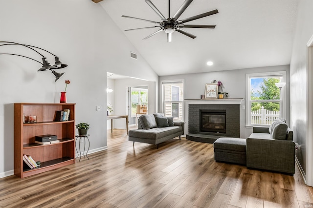 12909 Cocoplum Ct, Fort Wayne, IN 46814 - living area featuring high vaulted ceiling, wood finished floors, a fireplace, healthy amount of natural light, and a ceiling fan