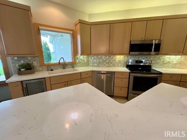 8018 Inverness Lakes Trl, Fort Wayne, IN 46804 - kitchen featuring stainless steel appliances, backsplash, healthy amount of natural light, and light stone counters