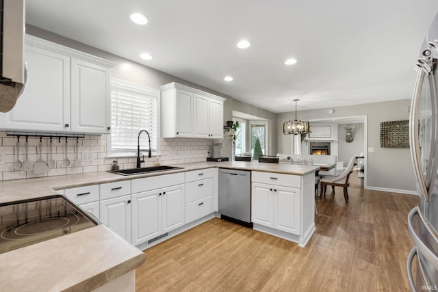 9628 Trading Post Rd, Leo, IN 46765 - kitchen featuring appliances with stainless steel finishes, a peninsula, light wood-style flooring, light countertops, and recessed lighting