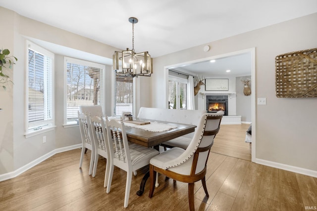 9628 Trading Post Rd, Leo, IN 46765 - dining space with a chandelier, a fireplace, and light wood-style floors