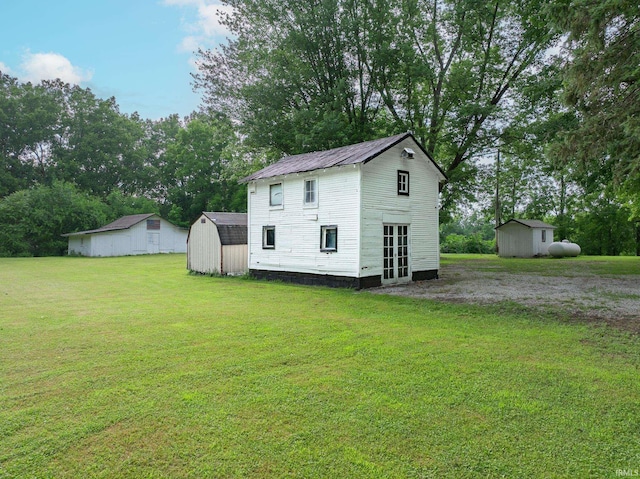 12632 N 325 E, North Manchester, IN 46962 - back of property with a storage shed, a lawn, and view of wooded area