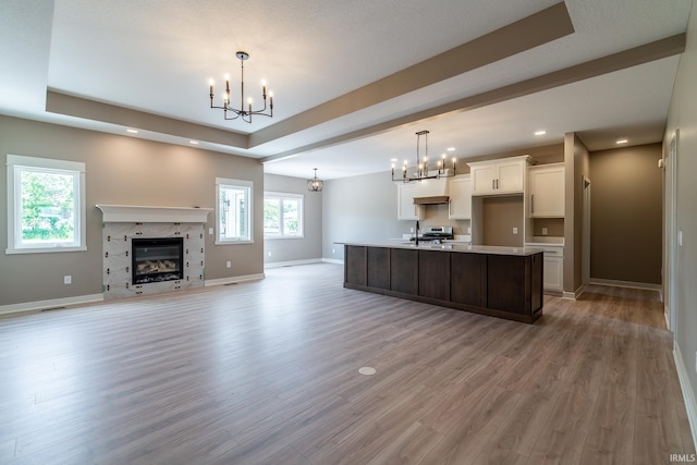 7751 Luna Way, Fort Wayne, IN 46835 - kitchen featuring a chandelier, light countertops, white cabinetry, a center island with sink, and light wood-type flooring