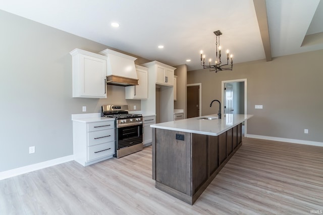 7751 Luna Way, Fort Wayne, IN 46835 - kitchen with stainless steel gas stove, light countertops, a chandelier, white cabinetry, and an island with sink