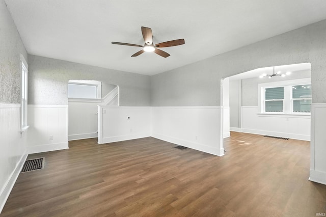 2020 Electric Ave, Fort Wayne, IN 46802 - spare room with a wainscoted wall, ceiling fan, wood finished floors, and a chandelier