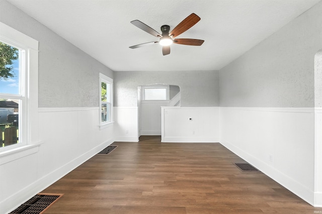 2020 Electric Ave, Fort Wayne, IN 46802 - unfurnished room with a wainscoted wall, ceiling fan, wood finished floors, and arched walkways