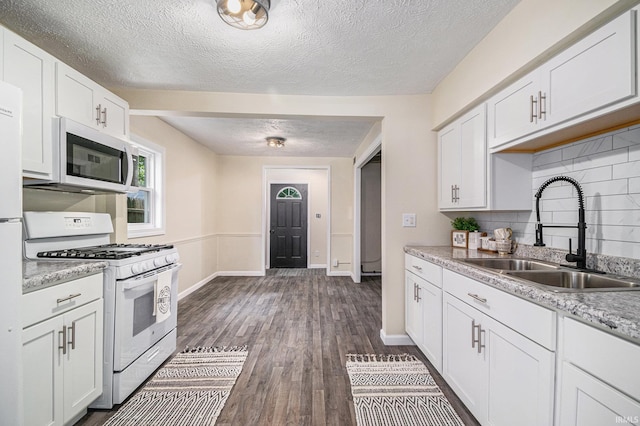 1641 N Adams St, South Bend, IN 46628 - kitchen with white appliances, a textured ceiling, decorative backsplash, white cabinetry, and dark wood-type flooring