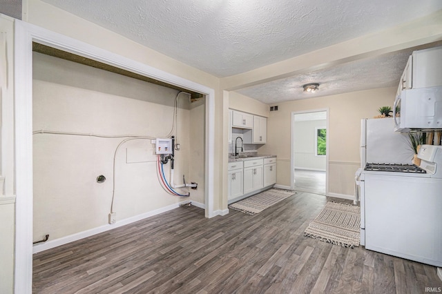 1641 N Adams St, South Bend, IN 46628 - kitchen with white appliances, a textured ceiling, wood finished floors, light countertops, and white cabinetry