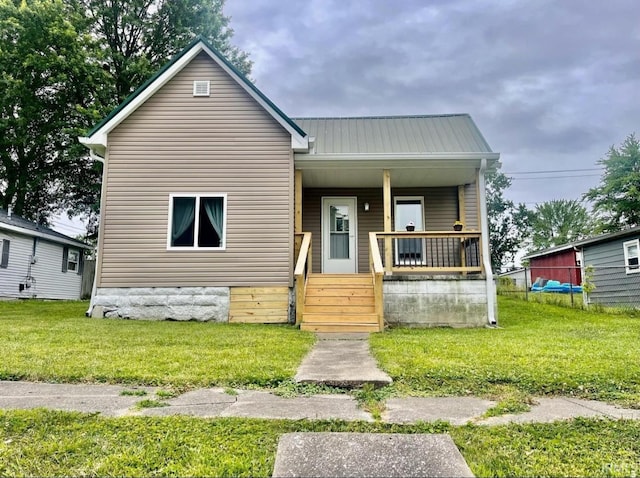 120 W Warren St, Mitchell, IN 47446 - view of front of house featuring covered porch, a front lawn, and a metal roof