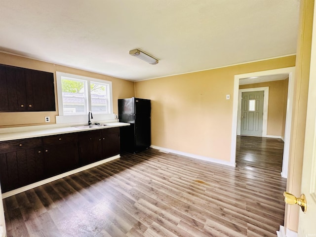 120 W Warren St, Mitchell, IN 47446 - kitchen with freestanding refrigerator, light wood-style flooring, light countertops, and dark brown cabinets