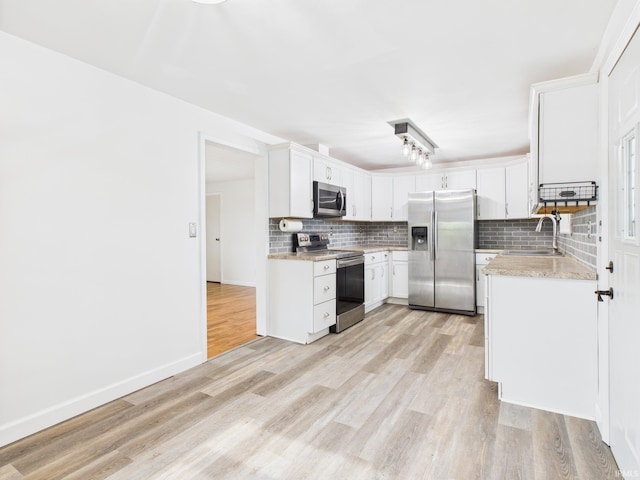 203 E Plum St, Frankton, IN 46044 - kitchen with stainless steel appliances, tasteful backsplash, light wood-type flooring, and white cabinets